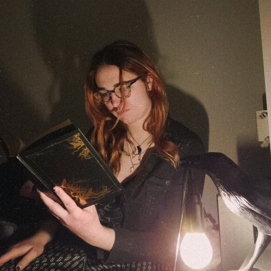 Penny reading a Poe book with dramatic lighting